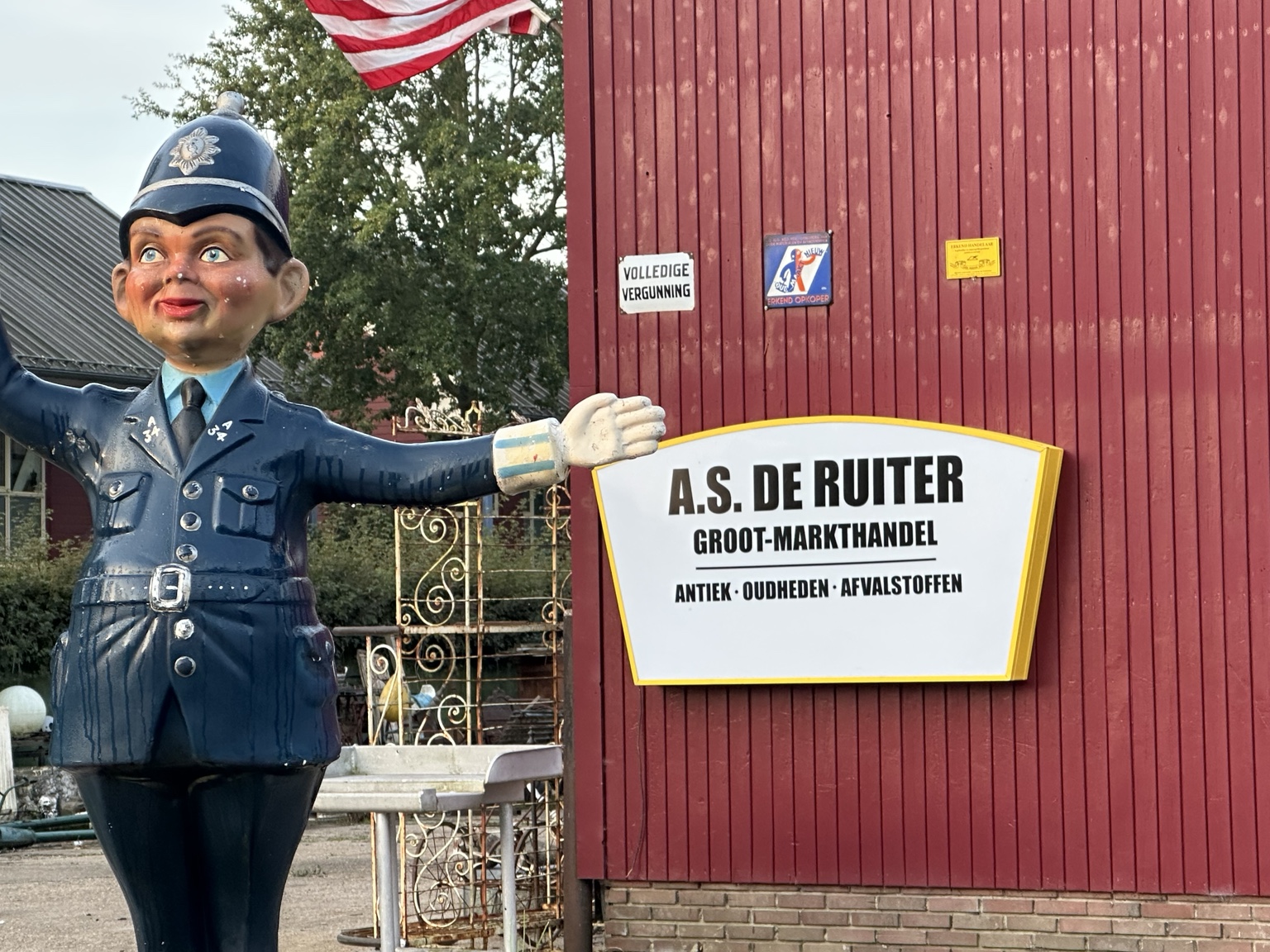 Het politiebeeld naast het bord A.S. de Ruiter Groot-markthandel bij de rode gevel van de zaak